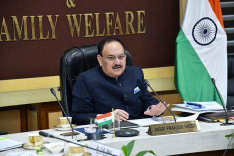 Jagat Prakash Nadda seated at a desk beneath a sign reading Family Welfare, national flag alongside