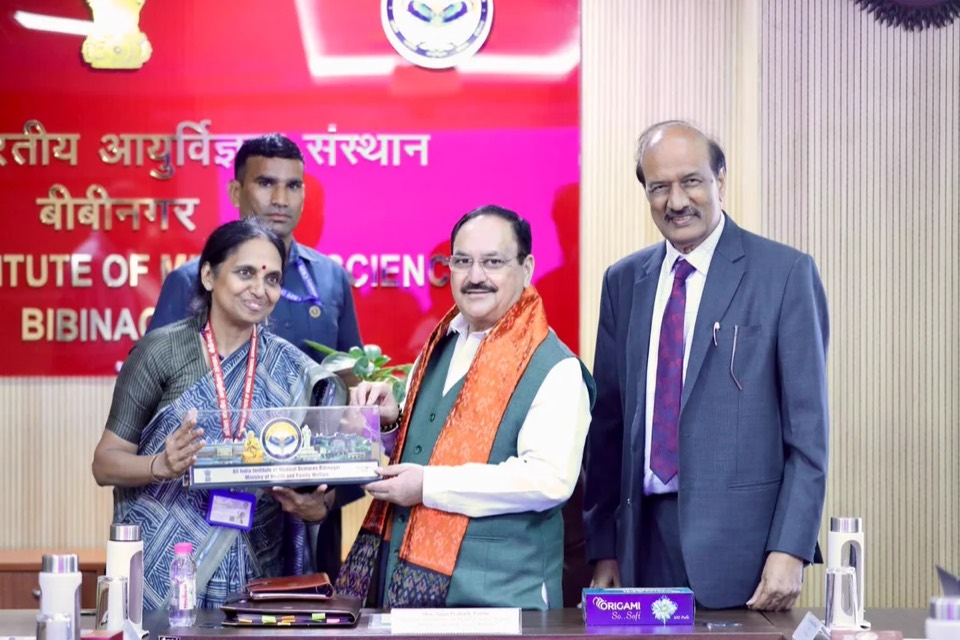 Jagat Prakash Nadda holding a memento with officials in front of an AIIMS Bibinagar backdrop