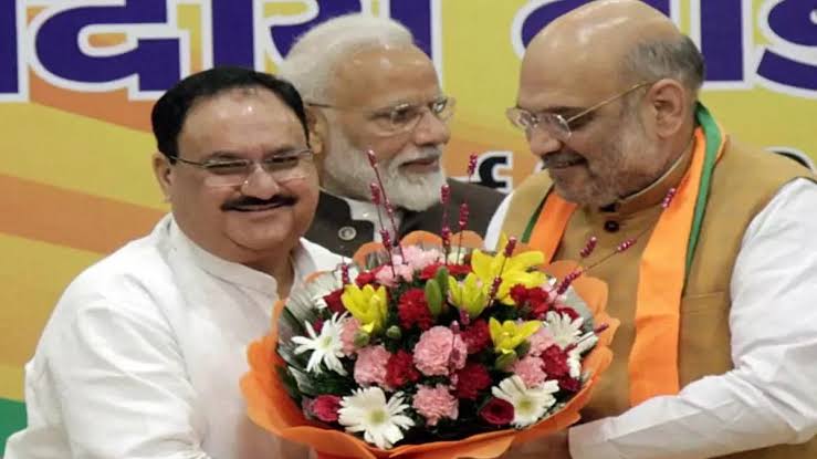 Jagat Prakash Nadda receiving a bouquet from Amit Shah while Narendra Modi looks on